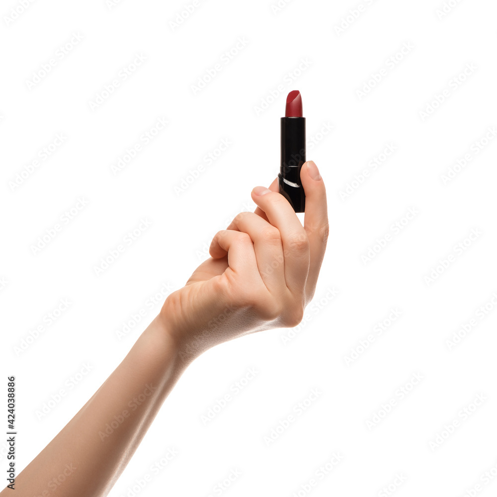 Red lipstick in a woman's hand on a white background, isolated. Red lipstick in a woman's hand on a white background, isolated.