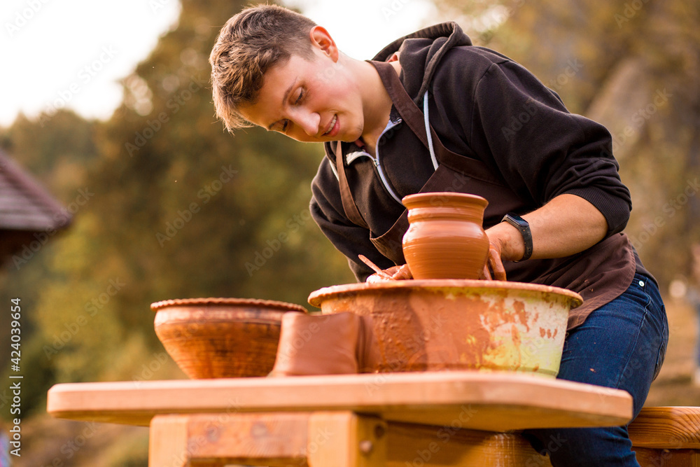 Man potter work with clay ware. Young handsome man potter on his workshop. Man potter work with clay ware. Young handsome man potter on his workshop.