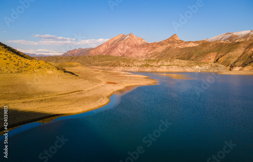 Panoramic aerial view on the lake and mountains at the bright sunny day. Beautiful landscape.