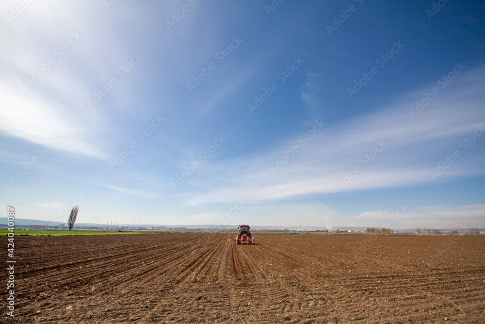 tractor sowing of seed to field at spring time tractor sowing of seed to field at spring time