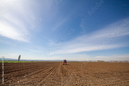 tractor sowing of seed to field at spring time