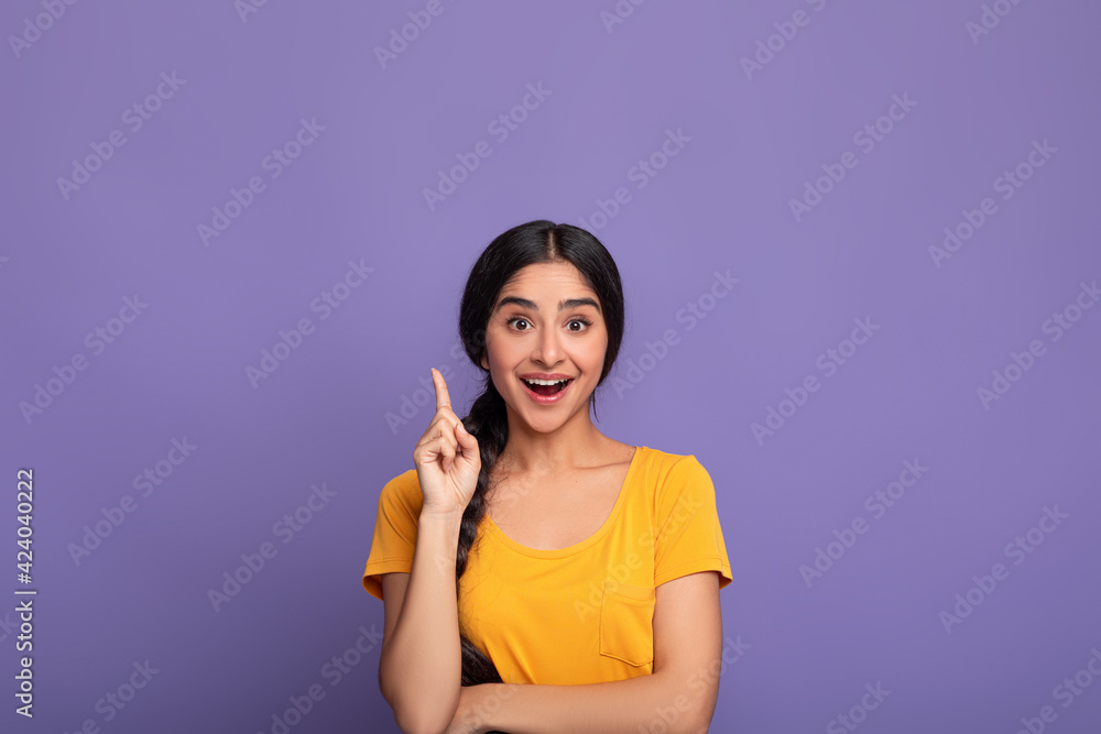 Excited indian woman has great idea and points up Excited indian woman has great idea and points up