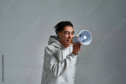 Young gypsy man screaming into megaphone