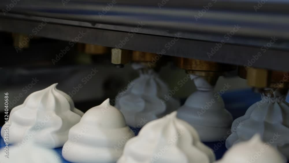 The molding machine squeezes the sweet cream onto the marshmallow conveyor line. Shallow depth of field. The molding machine squeezes the sweet cream onto the marshmallow conveyor line. Shallow depth of field.