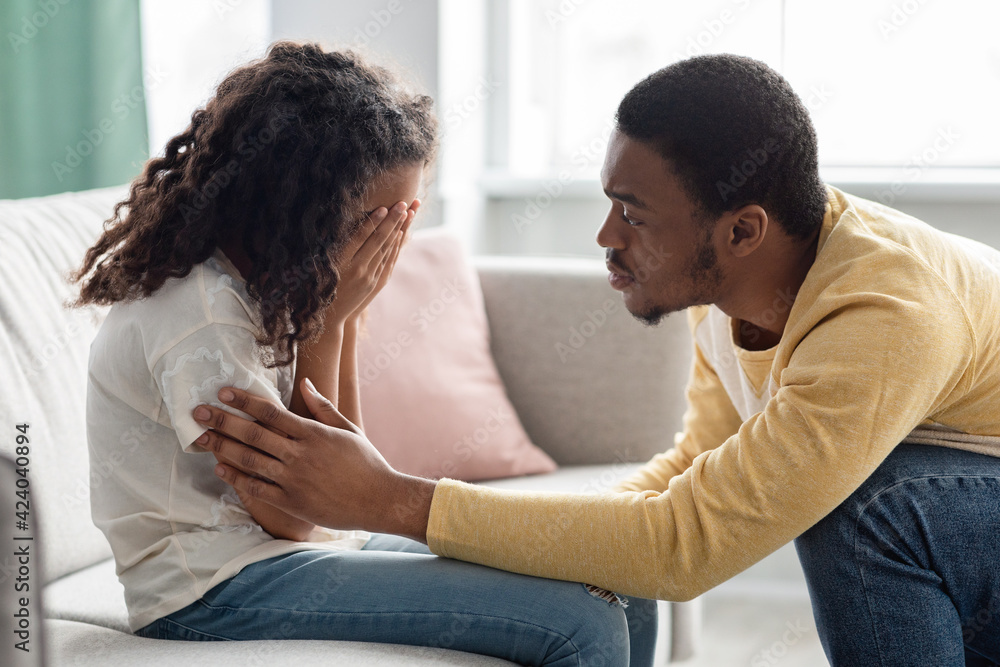 Foto Black father comforting his crying kid, home interior