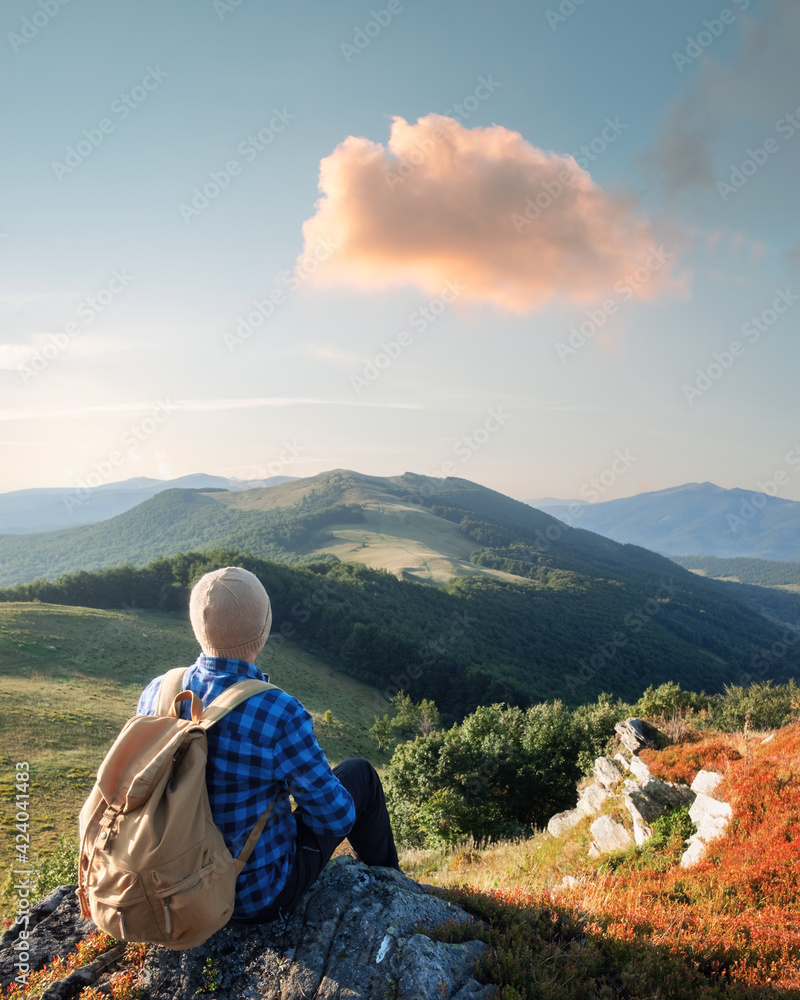 Fototapeta premium Alone tourist on the edge of the cliff against the backdrop of an incredible autumn mountains landscape