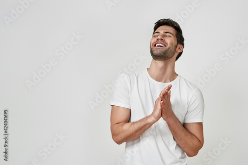 Happy bearded young man in white t-shirt laughing