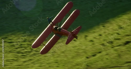 Aerial, stuntman on top of vintage planes fliers over countryside