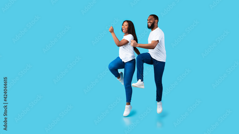 Happy young black couple walking and jumping at studio Happy young black couple walking and jumping at studio