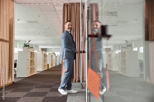 Happy adult caucasian man is working in a modern office