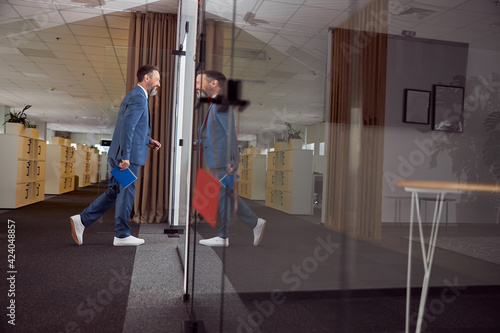 Happy adult caucasian man is working in a modern office