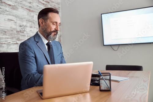 Happy adult caucasian man is working in a modern office