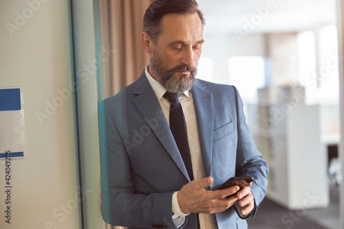Happy adult caucasian man is working in a modern office