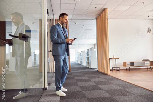 Happy adult caucasian man is working in a modern office