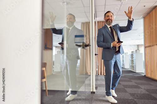 Happy adult caucasian man is working in a modern office