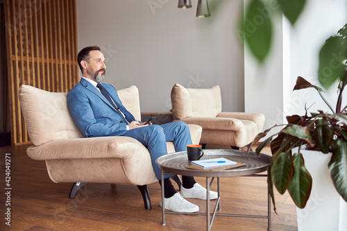 Happy adult caucasian man is working in a modern office