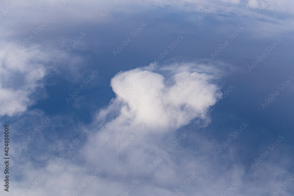 Fototapeta premium Stratosphere, a view of clouds from an airplane window. Cumuliform cloudscape on sky. Flying over the land.