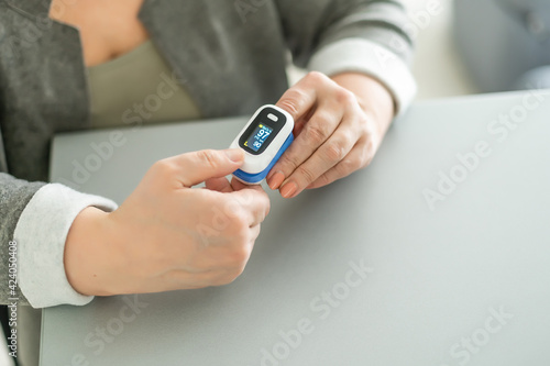 Bilde på lerret Old lady measuring her oxygen saturation with a pulse oximeter
