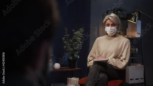 Wallpaper Mural Psychologist therapy session, woman and man wearing face mask sitting on the sofa and talking professional psychologist, psychiatric care consultation making notes during coronavirus COVID 19 lockdown Torontodigital.ca