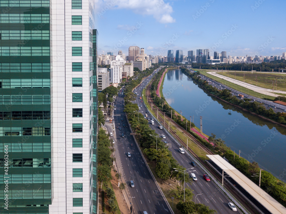 Drone aerial view of Marginal Pinheiros Avenue landscape, river, car traffic, buildings cityscape and Sao Paulo city skyline.	 Brazil. Concept of urban, metropolis, corporate, pollution, transport.