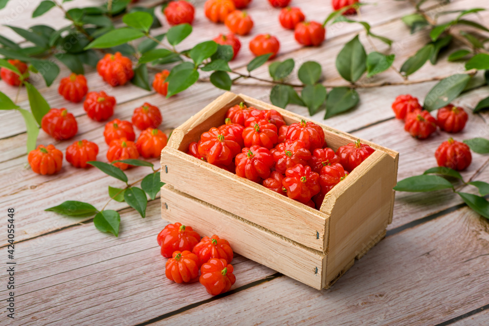 Suriname cherries in a small wooden box on a wooden surface. Suriname cherries in a small wooden box on a wooden surface.