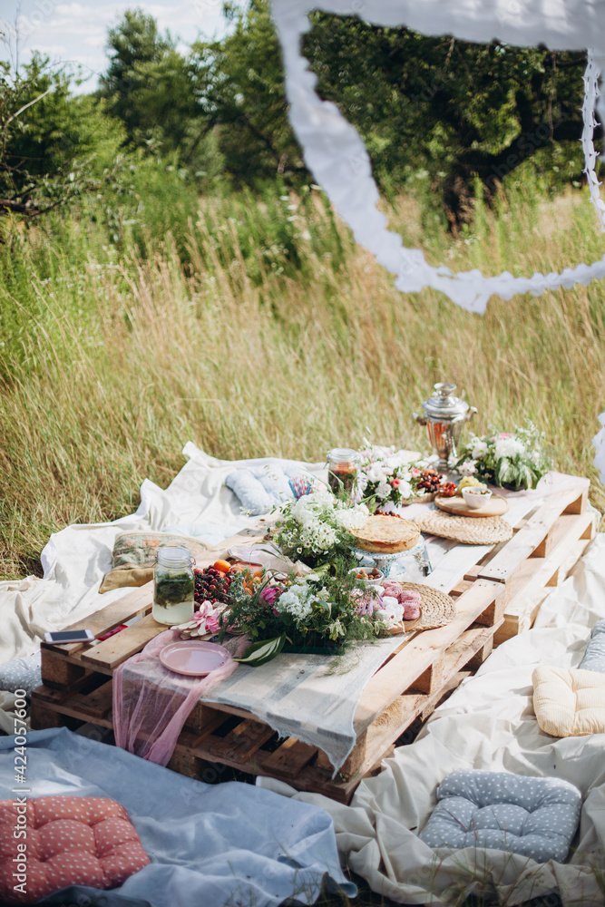pallet table in the park. decorated festive table in nature. outdoor summer  picnic. boho style wedding table Stock Photo | Adobe Stock