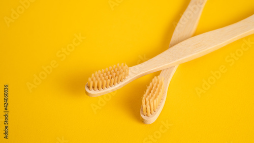Eco dental concept of bamboo toothbrush. Wooden toothbrush on yellow background with copy space