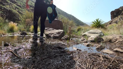 Woman walking in the river in the mountains