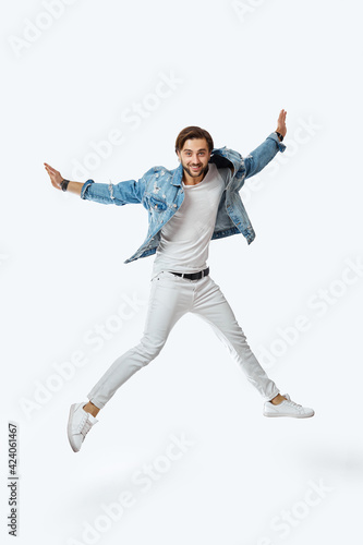 attractive crazy man in denim t-shirt jeans jumping