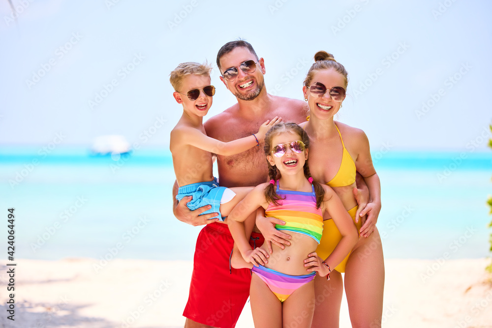 Happy family with kids on ocean shoreline