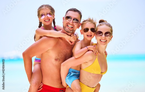 Happy family with kids on ocean shoreline
