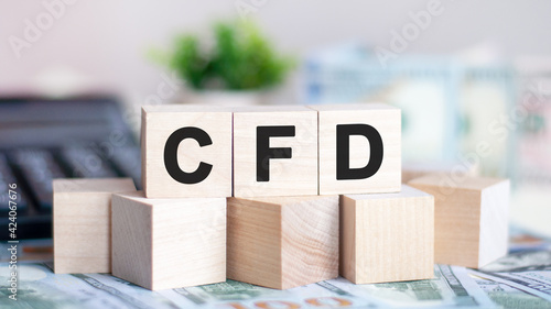 wooden blocks with text CFD and banknotes on table, concept photo