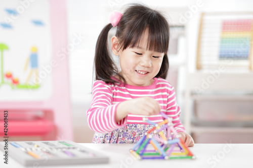 young girl playing creative 3d shape toy for home schooling