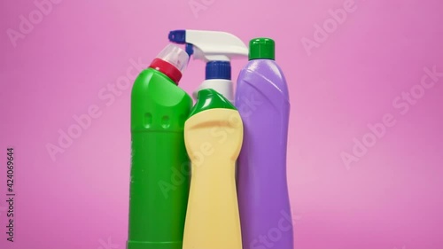 Four bottles of cleaning detergent. Green, yellow, and purple jar. Cleaning spray in a white plastic bottle. The concept of cleaning the house and chores around the house.