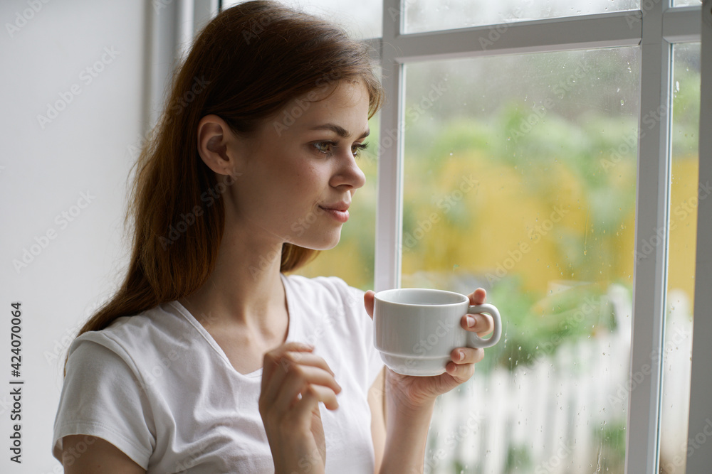 woman at home near the window with a cup of coffee interior vacation morning woman at home near the window with a cup of coffee interior vacation morning