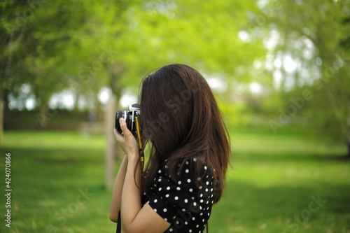 woman taking photo with film camera