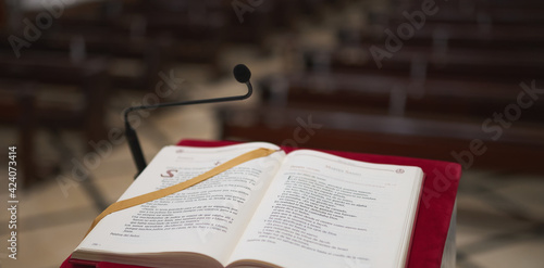 Fotografie marble lectern with a red felt and a bible with some pews in the