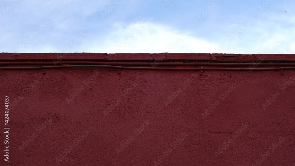 red facade roof detail against cloudy sky red facade roof detail against cloudy sky