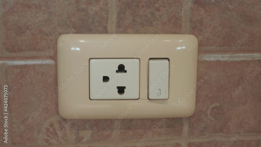 Close Up Man Hand Turn on the light from the wall switch in the room.