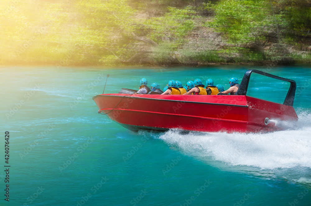 Fototapeta premium Riding people on a speedboat on a river at high speed. Motion blur effect.