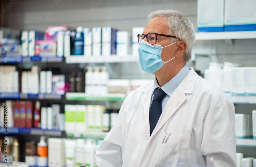 Pharmacist working in his pharmacy, coronavirus concept