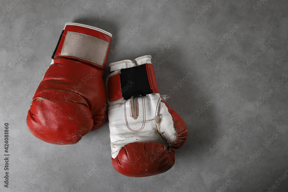 Boxing gloves on the gym floor after training. Gray grunge concrete background