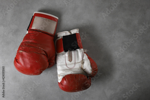 Boxing gloves on the gym floor after training. Gray grunge concrete background