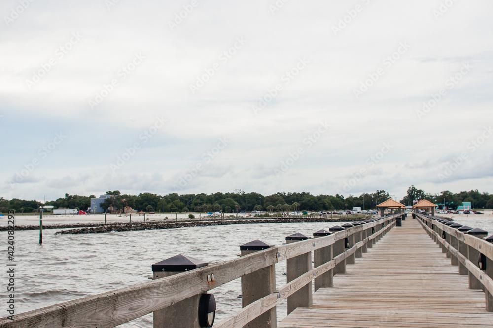 Seascape. Wooden pier with gazebos with orange roofs. Summer background. Ken Combs Pier, Gulfport, MS, USA