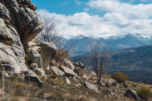 Beautiful landscape of rocky slope with mountains and clouds in the background