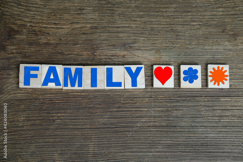 Fototapeta premium word family from volumetric colored letters on a dark wooden background, concept of marriage, weddings, honeymoon time, content loading process