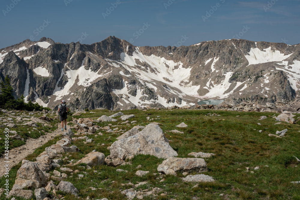Woman Hikes Alongside Alpine Meadow High in the Teton range