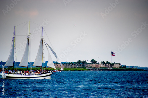 A sailboat in the Charleston Harbor with the Castle Pinckney in the background