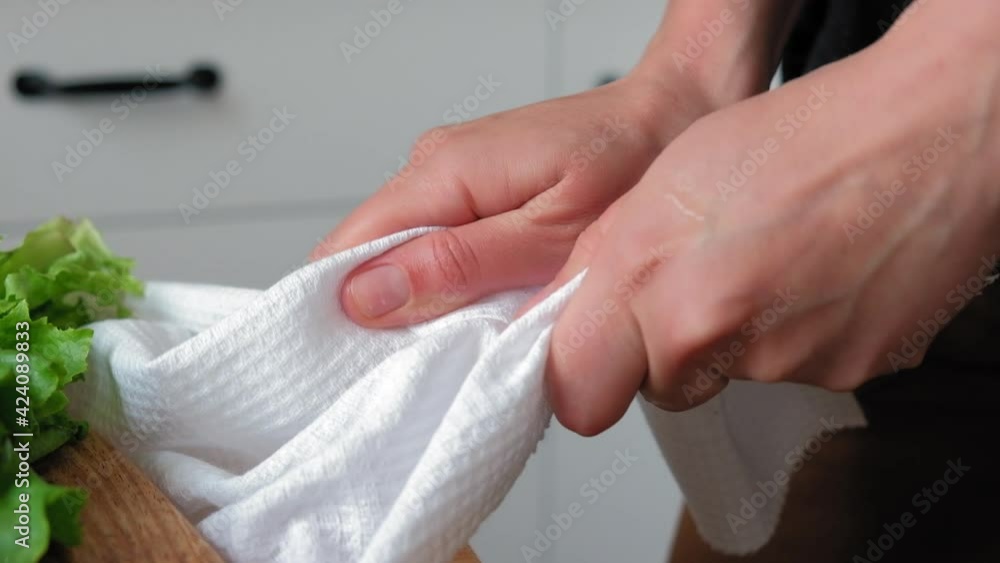 The chef wipes his hands on a white towel. Girl wipes her hands on a white towel close-up in slow motion The chef wipes his hands on a white towel. Girl wipes her hands on a white towel close-up in slow motion