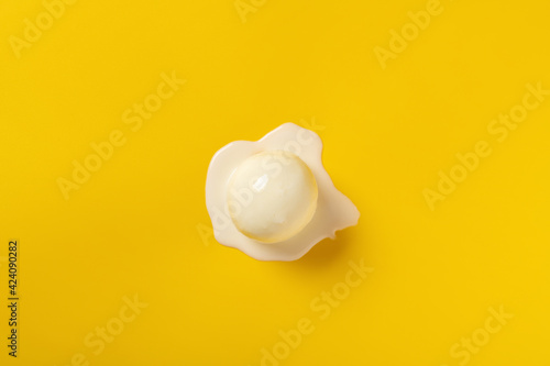 top view vanilla flavor ice cream ball in a melting process on yellow background